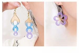 Detail of glitter geometric and flower resin earrings worn by a model in gradient colors