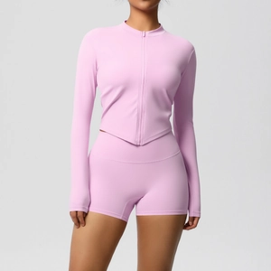 Detailed shot of pink yoga set featuring a zip-up jacket with triangular hem and shorts