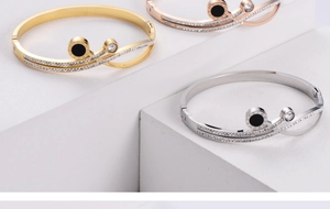 Détail de trois bracelets en titane tricolore avec chiffres romains et cristaux