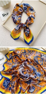 Detail of vintage floral pattern on orange and blue silk scarf showing fine fabric texture