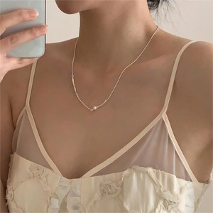 Mirror selfie showing a 925 sterling silver pearl necklace on a woman's collarbone