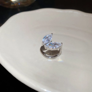 Bague en argent avec zircons marquise sur une assiette en céramique blanche