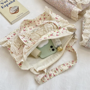 Détails de l'intérieur d'un sac cabas floral en toile avec bordure en dentelle et accessoires