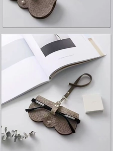 Détail de l'étui à lunettes en cuir PU taupe texturé avec rabat ondulé et bouton pression