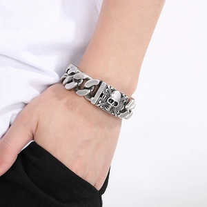 Detailed close-up of retro silver skull bracelet with vintage chunky curb chain link texture