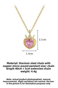 Detailed close-up of pink heart pendant with gold crown and sparkling zircon stones