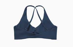 Détail d'un soutien-gorge de sport bleu foncé avec bretelles croisées et nœud au dos