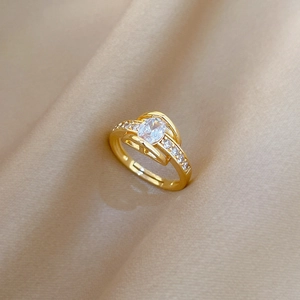 Adjustable gold ring with marquise cut crystal on champagne silk background