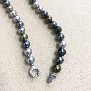 Close-up of multicolor Tahitian style pearls with a shimmering silver diamond clasp