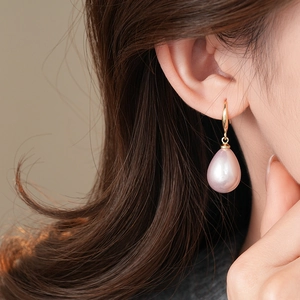 Detailed view of water-drop faux pearl earrings in pink-purple with gold metal ear hooks