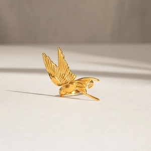 Golden peace dove stainless steel open ring with detailed feather texture in sunlight