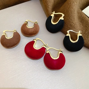Macro detail of vintage flocked metal U-shape hoop earrings in brown, black and red