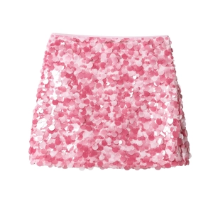 Detailed view of pink sequins on a knit mini skirt showing texture and metallic luster