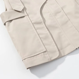 Detail view of the high-quality stitching and fabric texture on a beige trench coat