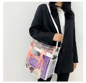 Detailed view of large transparent PVC tote bag with pink straps and inner mesh pockets