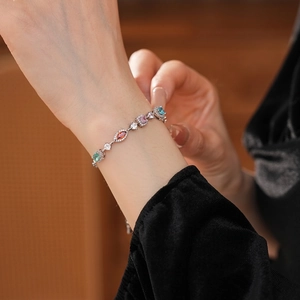 Elegant silver bracelet with multi-color oval zircons worn on a wrist for a luxury look