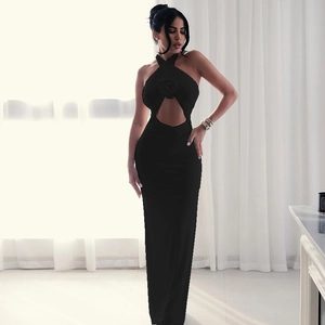 Detail of black halter maxi dress with 3D floral accent and waist cutout design