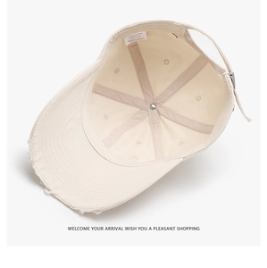 Detail view of beige cotton baseball cap interior showing stitching and 100% cotton label