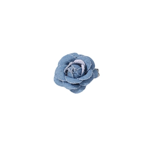 Detailed view of a handmade blue denim camellia flower brooch with textured edges