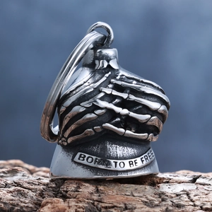 Gothic silver skull bell pendant with Born To Be Free engraving on wood and blue background