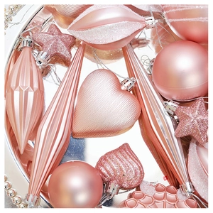 Close-up of rose gold and pink Christmas ornaments in heart, star, and sphere shapes