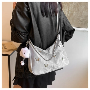 Silver-grey pleated shoulder bag with metal butterfly, chain strap and plush bear charm