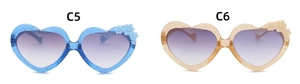Detail of glitter heart-shaped sunglasses with flower accents in blue and champagne gold