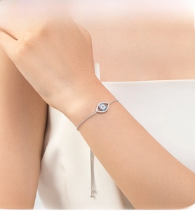Macro detail of S925 sterling silver evil eye bracelet with adjustable chain and blue stones