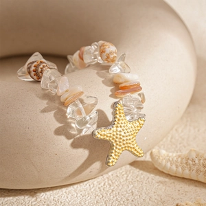 Détail d'un bracelet style océan avec une étoile de mer jaune et des perles en coquillage
