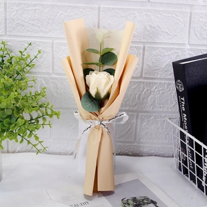 Detail view of a single rose soap flower in beige paper with a 'Just for you' white ribbon