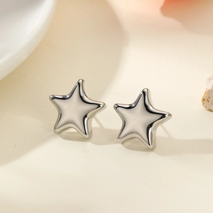 Macro detail of silver pentagram stud earrings with a high-polished metallic finish