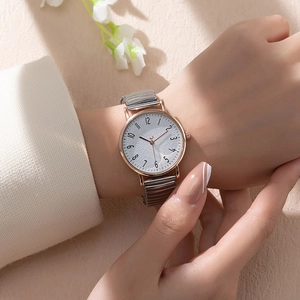 Women's quartz watch with rose gold case and elastic two-tone strap on model wrist