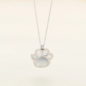 Silver stainless steel cat paw pendant necklace with white inlay on plain background