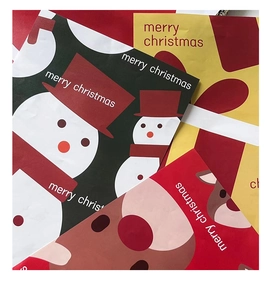 Close-up of Christmas wrapping paper with festive snowman and reindeer cartoon patterns