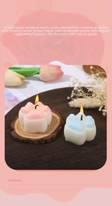 Close-up of pink and blue cat paw scented soy candles on a circular wooden base