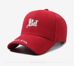 Détail d'une casquette rouge en coton avec broderie Bd blanche et texte Team Club latéral