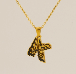 Detail of letter K pendant with golden floral pattern on black background necklace