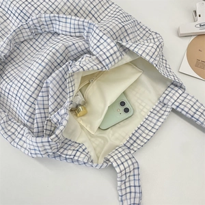 Detail of blue plaid canvas tote bag interior with zipper pocket for phone and cream