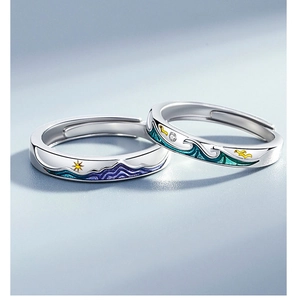 Detail of couple rings with mountain and sea enamel design and sparkling small zircon stone