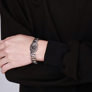 Close-up of a silver Masonic All-Seeing Eye pendant on a chunky punk chain bracelet