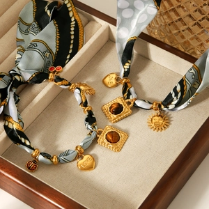 Silk scarf necklaces with gold heart and sun pendants featuring tiger eye stones