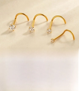 Macro shot of G23 titanium nose studs with sparkling zircon in four different sizes