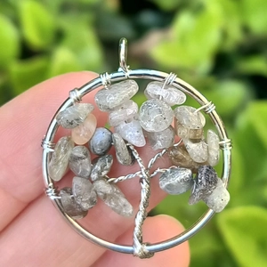 Macro shot of tree of life pendant with silver wire wrap and grey natural stones