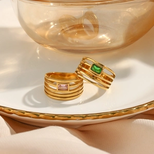 Détail de bagues multicouches plaquées or 18K avec zircons rectangulaires vert et rose