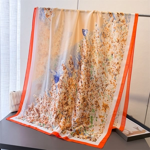 Close-up of lightweight silk-like scarf with orange floral field and blue butterfly print