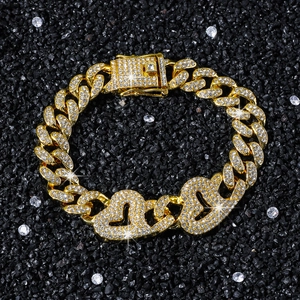 Men's hip hop gold Cuban link bracelet with iced out double heart charm on black background