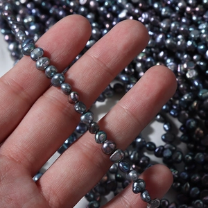 Strand of iridescent baroque natural freshwater pearls in dark peacock green and purple