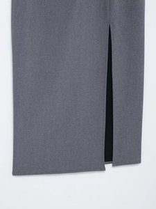 Gros plan de l'ourlet de la robe gris foncé avec fente latérale et texture de tissu tissé