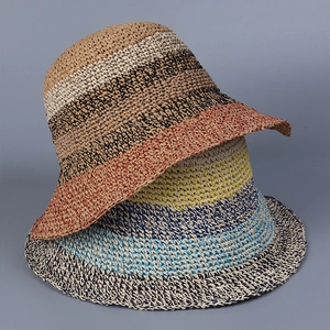 Detailed close-up of striped hand-woven straw hats in vibrant multi-color patchwork style