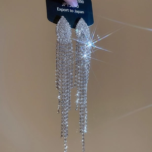 Detailed close-up of sparkling crystal jellyfish tassel earrings on black card